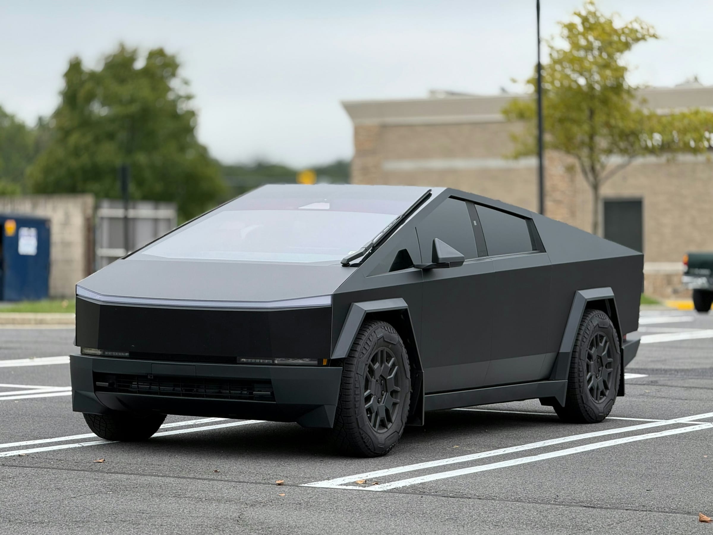 Black-wrapped Tesla Cybertruck in a parking lot
