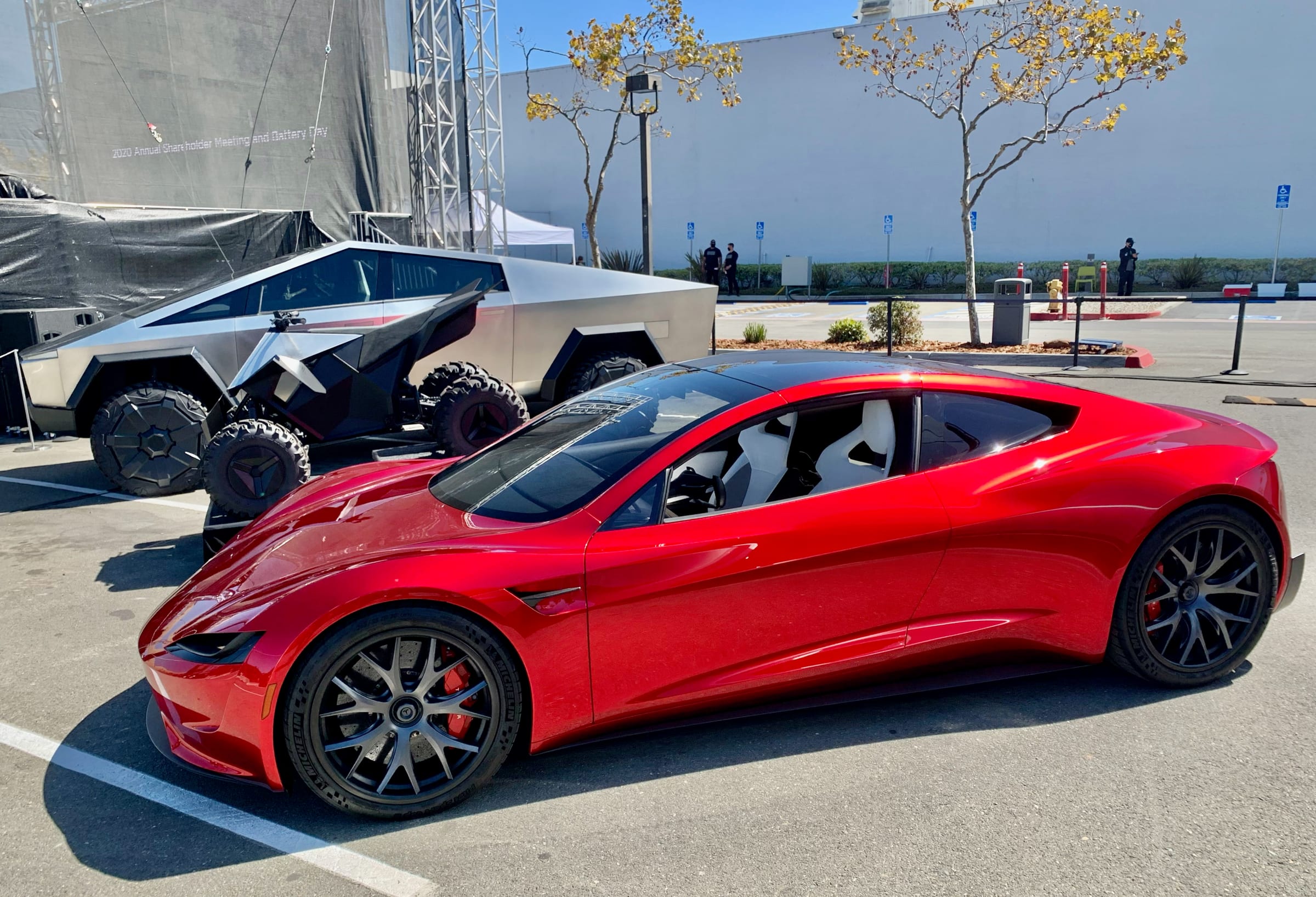 Red Tesla Roadster prototype beside a Cybertruck