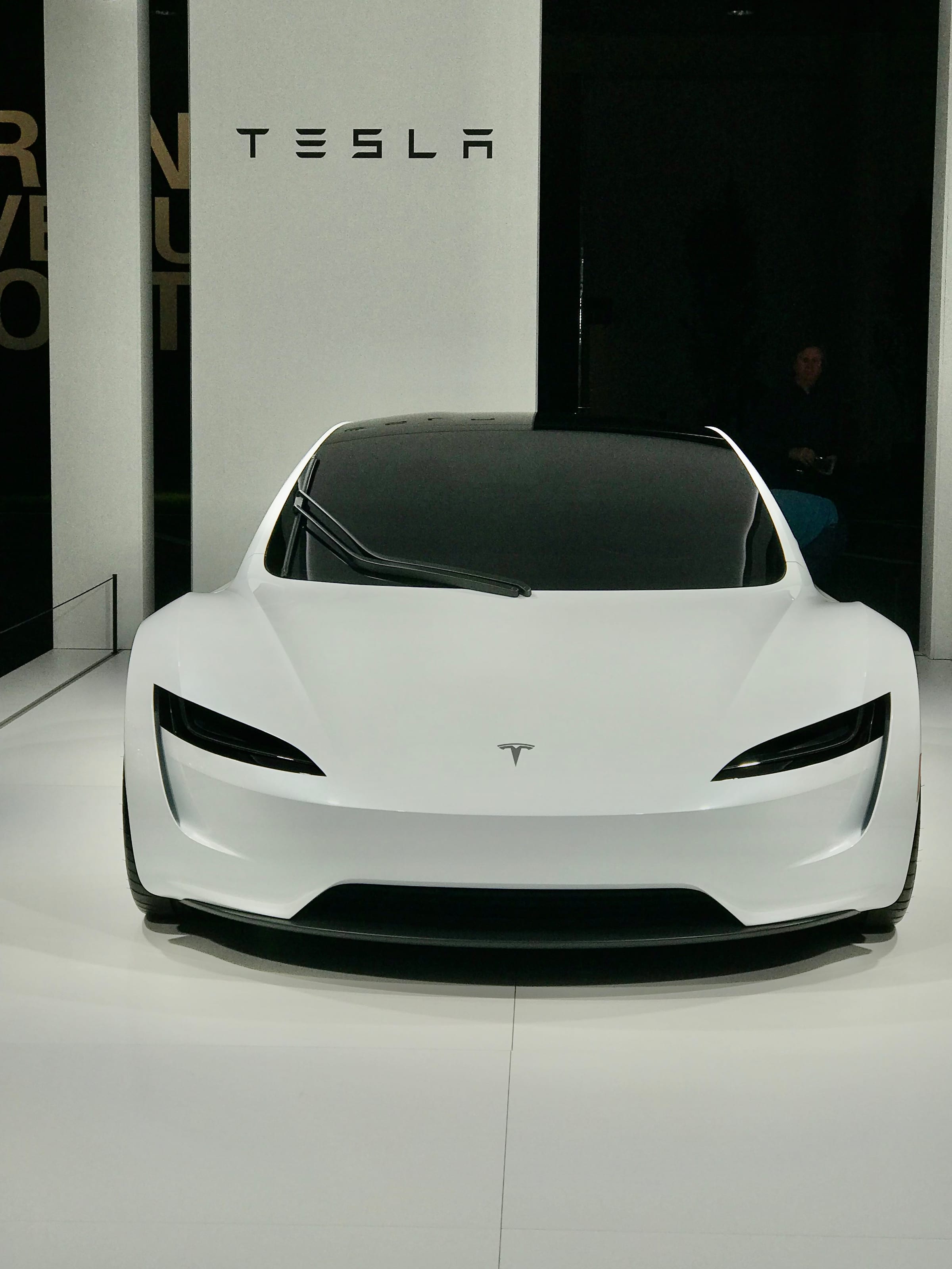 Front view of a white Tesla Roadster prototype in a showroom